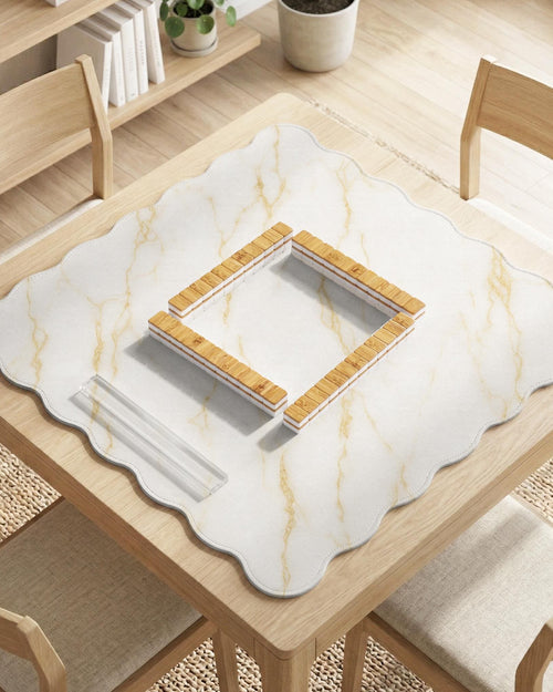 White marble mahjong mat with gold veining and a scalloped decorative edge.