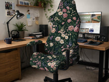 Dark botanical floral print chair cover shown on a black high back gaming chair with armrests.
