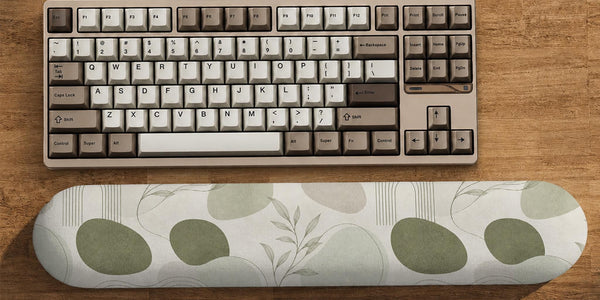 Sage green desk mat and wrist rest design with abstract botanical shapes and fine line details on a light background.