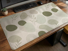Sage green desk mat with a botanical leaf pattern in a minimal style.