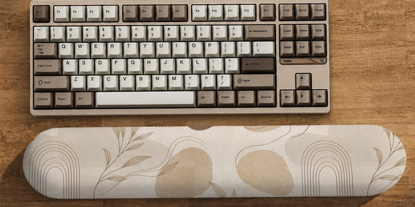 Cream desk set with a botanical pattern, fine line abstract shapes, a matching mousepad, and a long keyboard wrist rest.
