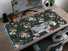 Dark green desk mat with pink roses, ivory flowers, lavender stems, and layered botanical foliage.