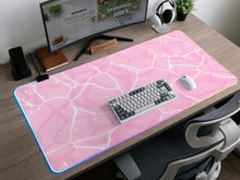 Pastel pink desk mat with a marble-style design, white flowing lines, and small sparkle accents.