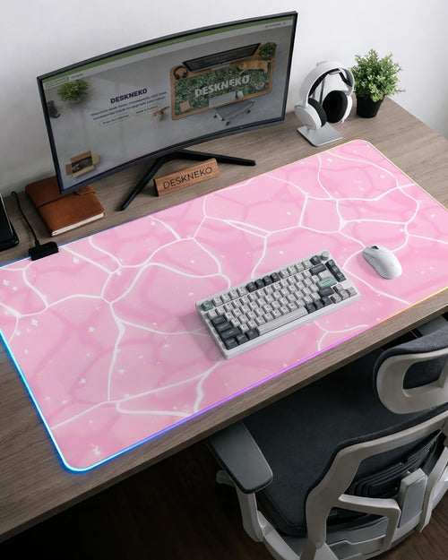 Pastel pink desk mat with a marble-style design, white flowing lines, and small sparkle accents.