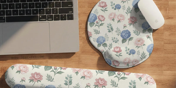 Mousepad and keyboard wrist rest with a floral print of blue hydrangeas, pink peonies, sage leaves, and a cream background.