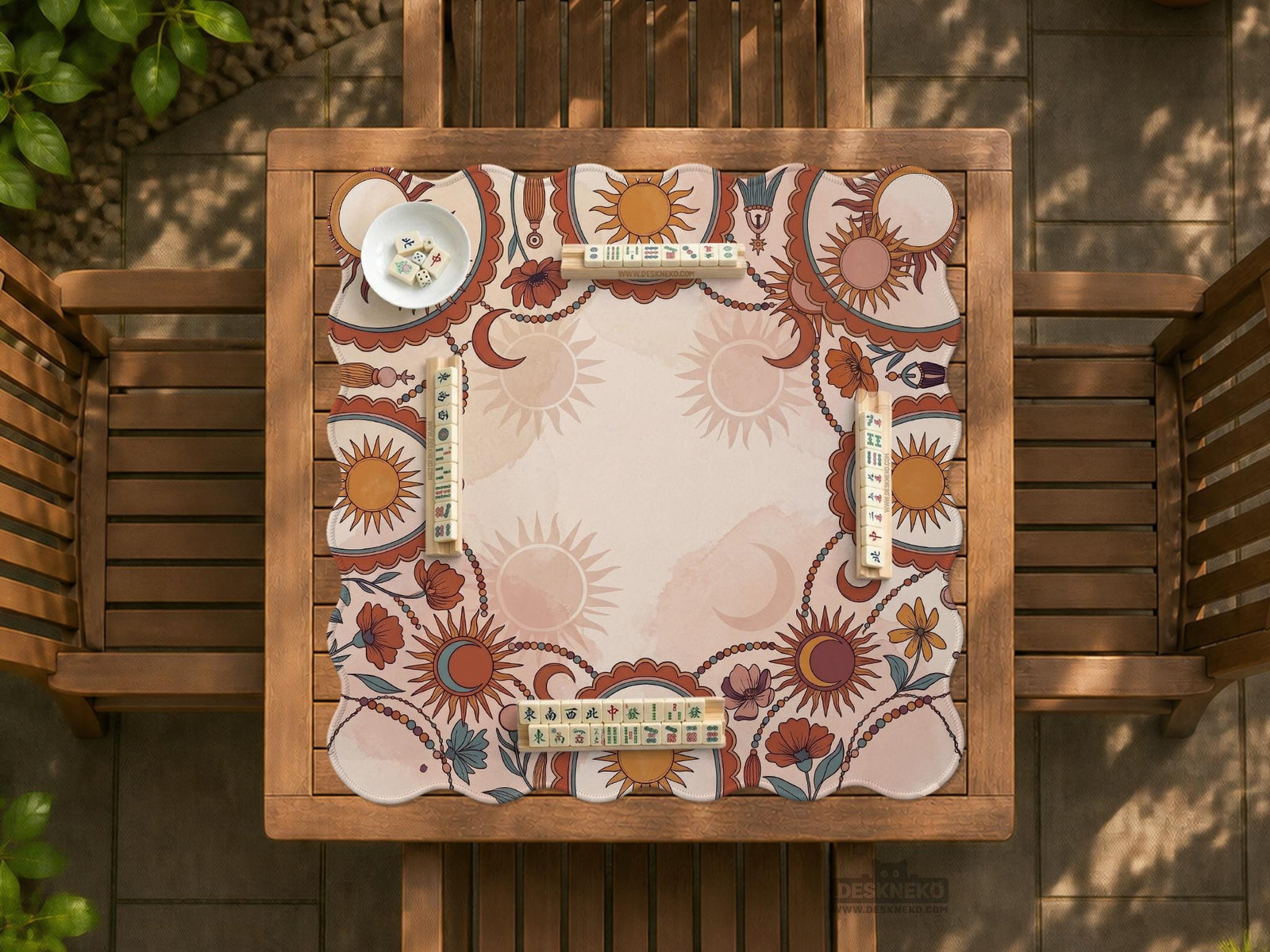 A square mahjong mat with a scalloped edge, sun and moon artwork, terracotta flowers, a soft cream background, and a decorative border around the play area.