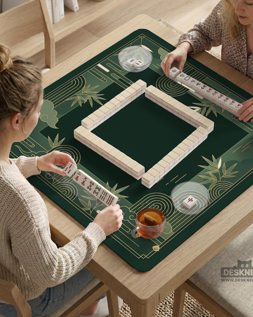 Square emerald green mahjong mat with bamboo line art, gold geometric cloud shapes, and a plain center playing area.