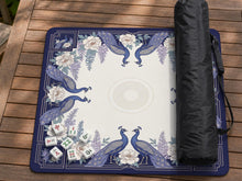 Blue mahjong mat with a floral peacock border and an open center area for tile play.