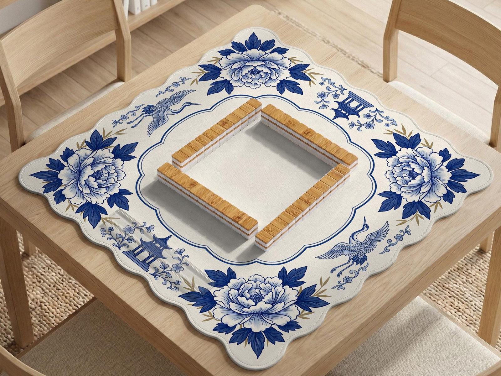 Blue and white mahjong mat with cranes, floral porcelain-style artwork, a cream center area, and a decorative border.