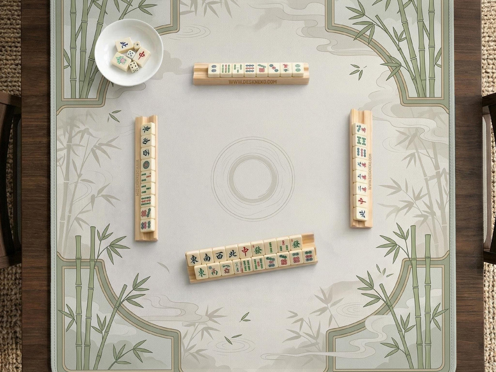 A square cream mahjong mat with sage bamboo corners and soft cloud details around an open center area.