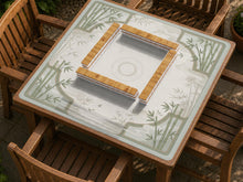 Square mahjong table mat with a pale cream center and green bamboo chinoiserie corners and border.