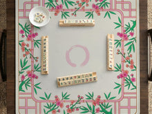 Pink cherry blossom floral mahjong table mat with a cream center and bamboo-style border design.