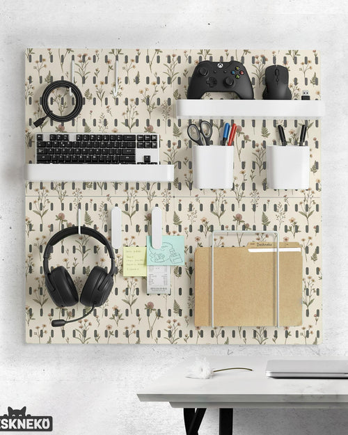 Cream pegboard wall organizer with small floral print, sage green stems, black slot layout, shelves, hooks, clips, and containers.