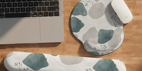 Sage green ergonomic mousepad and keyboard wrist rest with abstract shapes, soft gray details, cream space, topographic contour lines, and leafy branch accents.