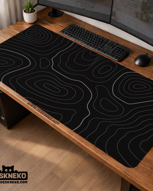 Black desk mat with a thin gray topographic contour line pattern.