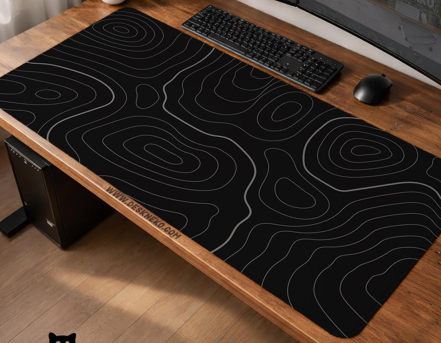 Black desk mat with a thin gray topographic contour line pattern.