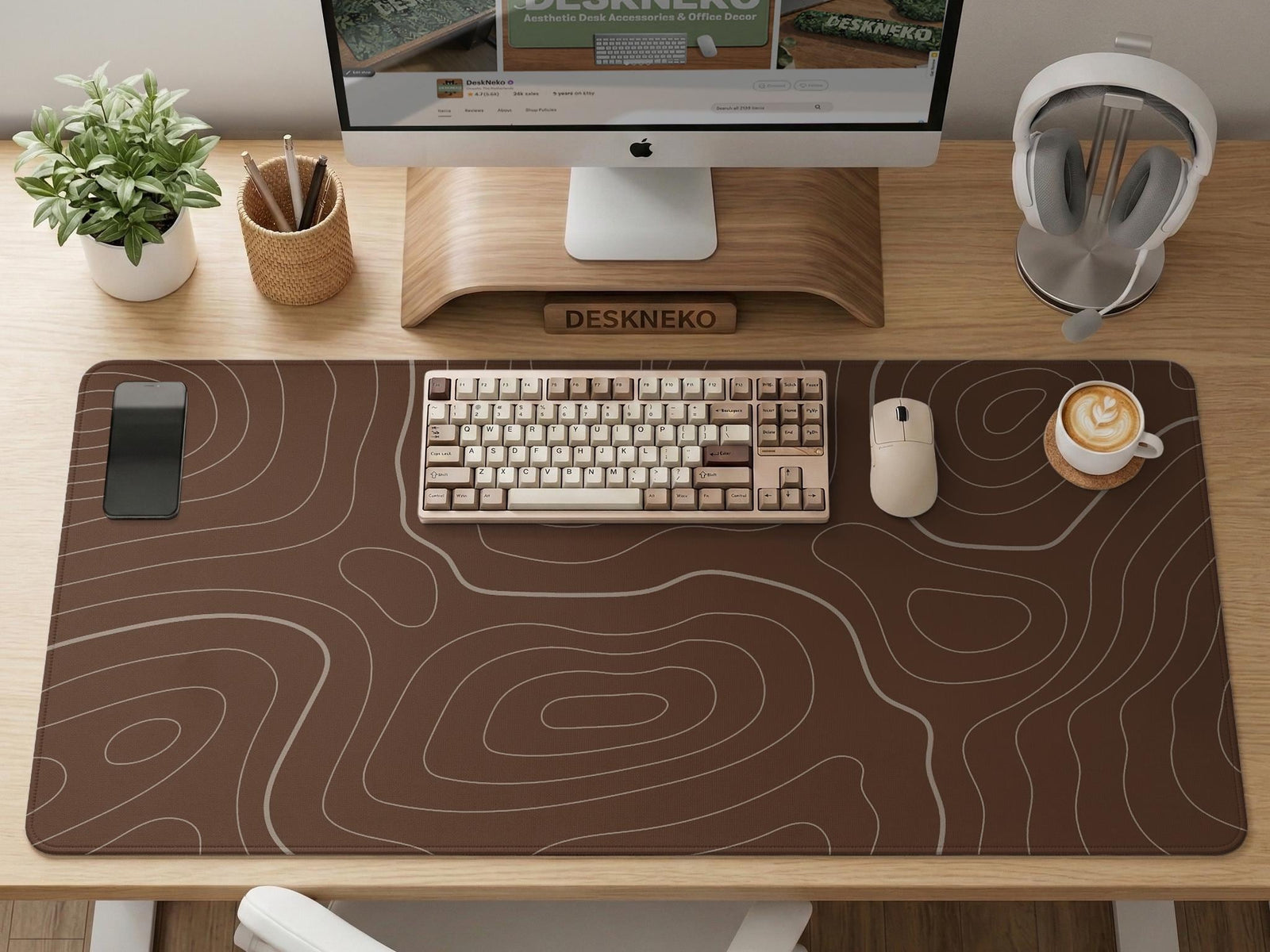 Brown desk mat with a repeating topographic contour line pattern in a neutral earth tone design.