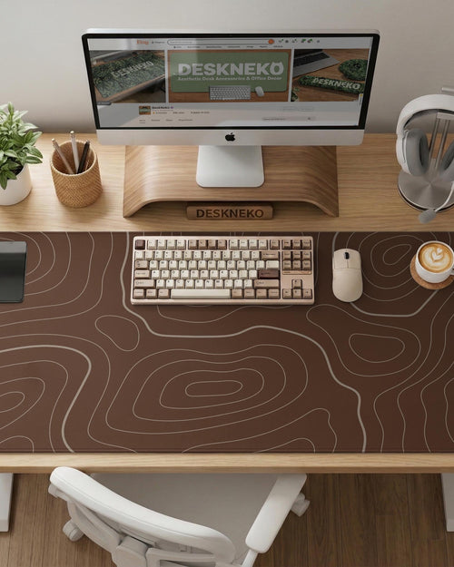 Brown desk mat with a repeating topographic contour line pattern in a neutral earth tone design.