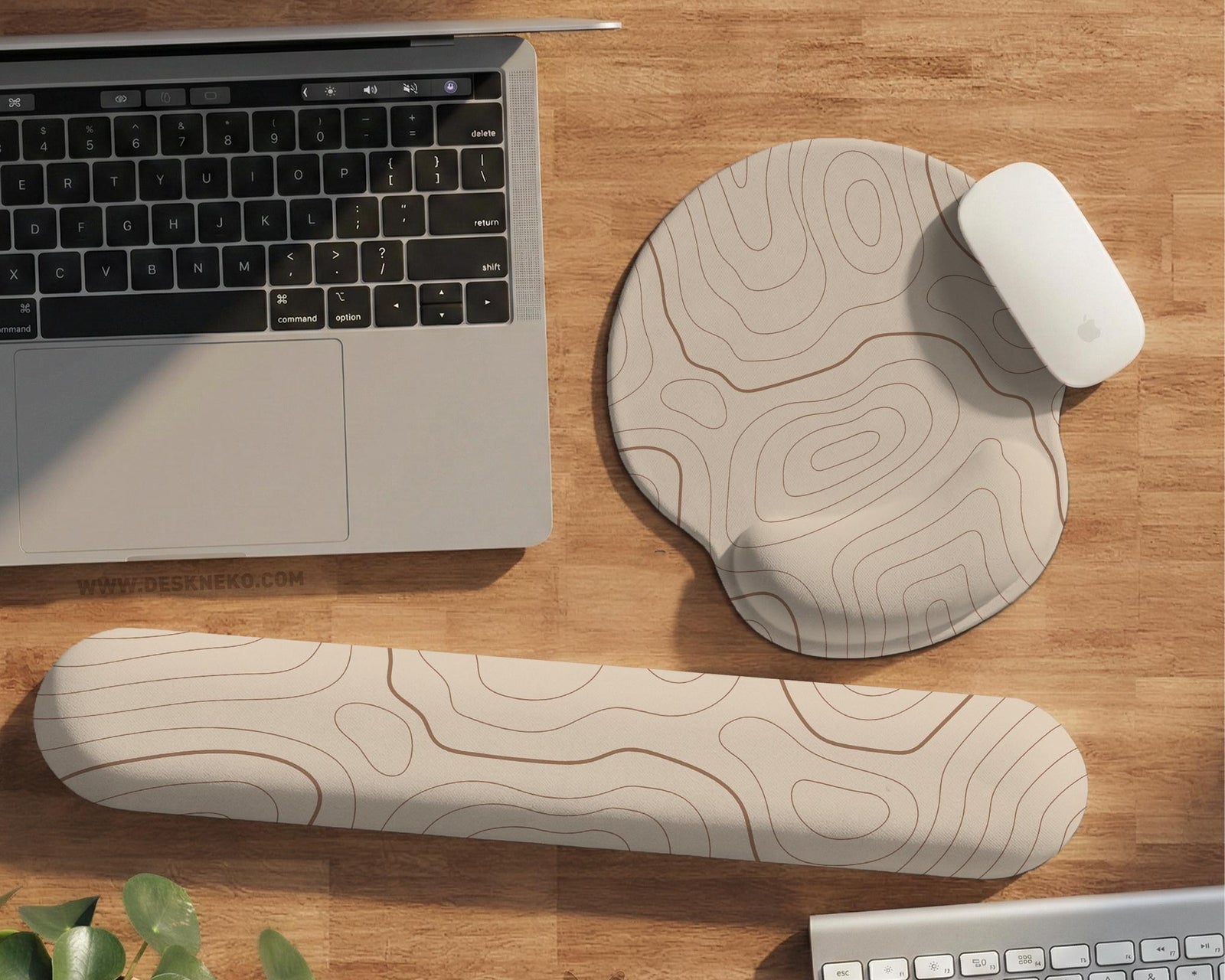 Beige mousepad and keyboard wrist rest with a topographic line pattern shown in a neutral desk setup.