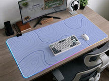 A pastel blue mousepad with an abstract topographic contour line pattern.