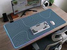 Blue mousepad with a topographic line pattern on a slate background.
