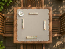 Beige square mahjong table mat with a scalloped edge shown on a plain background.