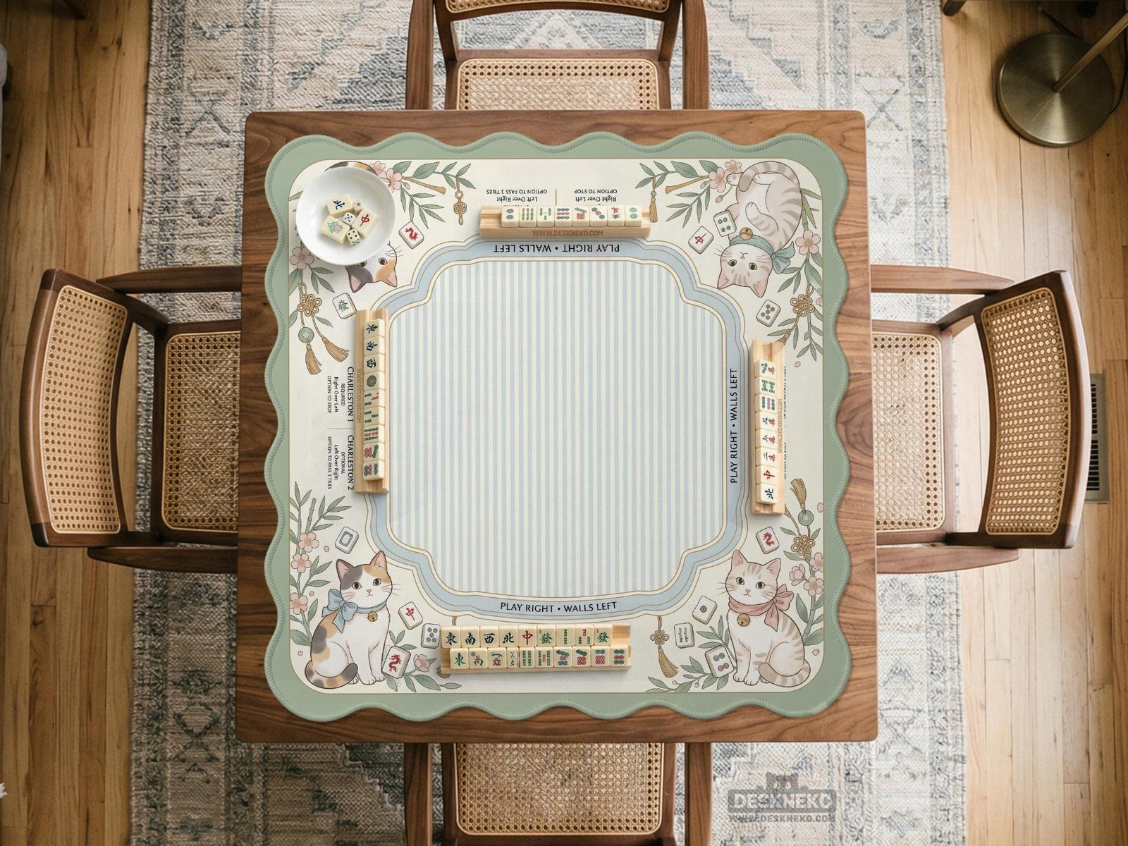Square pastel mahjong mat with a cat illustration, blue stripes, cream background, floral corner details, and printed rules around the edge.