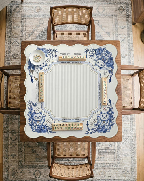 Blue and white square mahjong mat with lucky cat artwork, floral chinoiserie pattern, tile icons, and a rule guide layout.