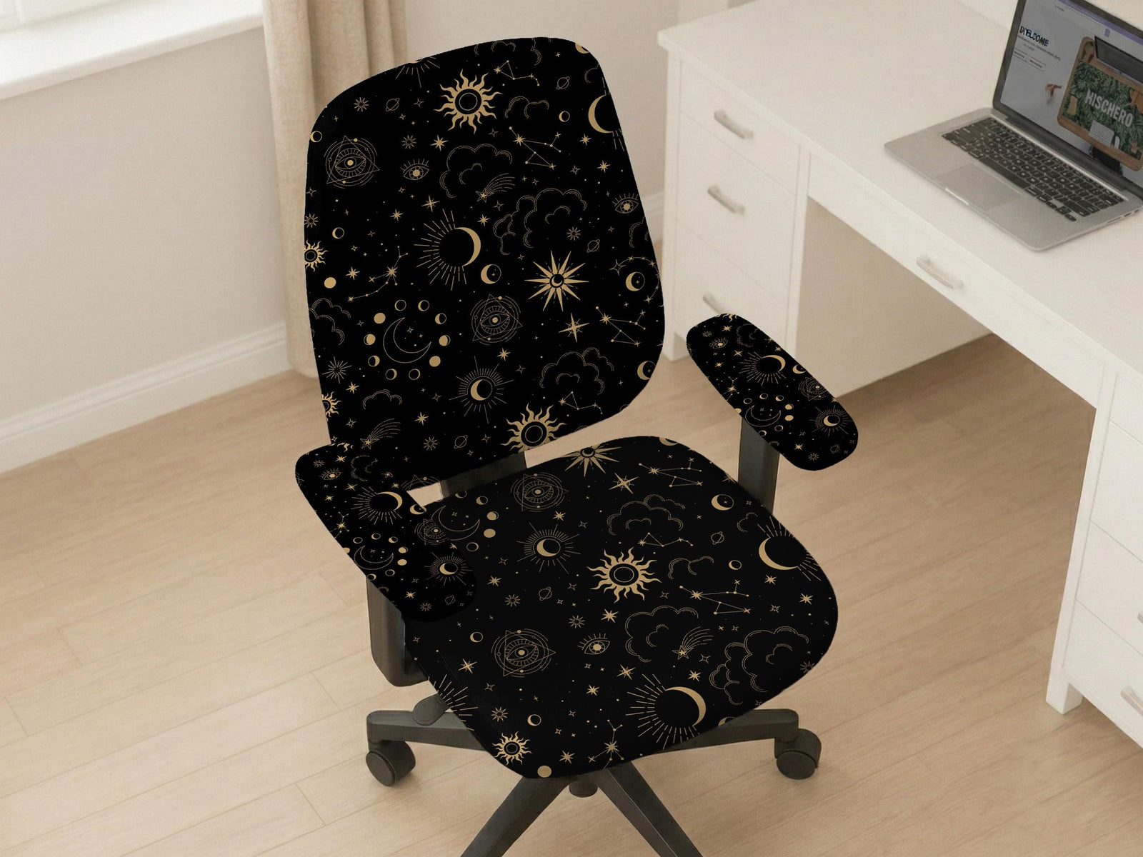 Black chair cover with gold moons, suns, stars, constellations, and line art printed across the fabric.