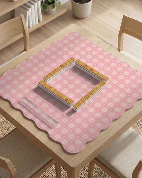 Pink scalloped square mahjong mat with a gingham check pattern, small flowers, and tiny heart details.