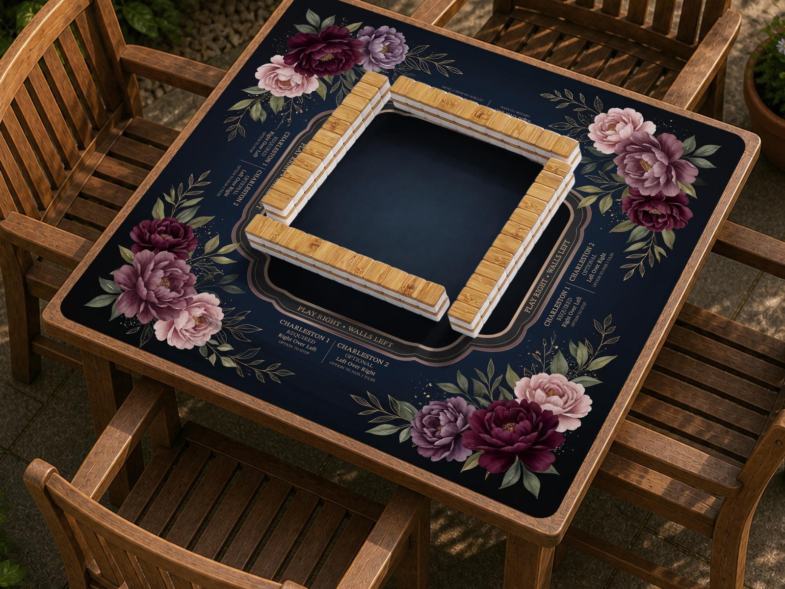 A burgundy floral mahjong mat with a peony border, blush pink and sage leaves, gold accents, and printed rules around an open center.