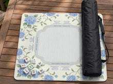 Blue hydrangea floral mahjong mat with a cream background, sage green vines, a striped center, and printed rule notes around the border.