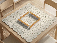 Cream mahjong mat with a floral pattern of small wildflowers and sage leaves, shown with a scalloped edge on a light neutral background.