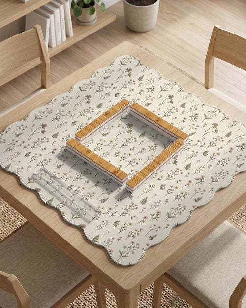 Cream mahjong mat with a floral pattern of small wildflowers and sage leaves, shown with a scalloped edge on a light neutral background.
