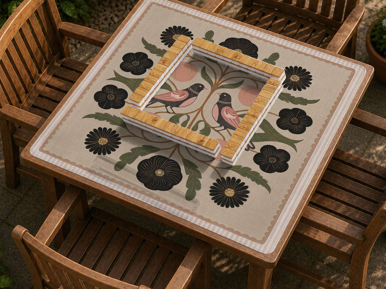 Olive-colored mahjong mat with bird and floral artwork, blush fruit accents, black flowers, and a beige woven-look background.