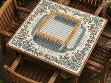 Square mahjong mat with floral botanical artwork around the edges, a light center, soft stripe details, and printed rule bands.