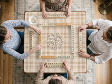 Beige and tan plaid square mahjong mat shown as a large table play surface.