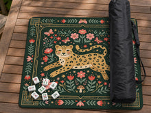 Dark green square mahjong mat with a golden spotted leopard in the center, surrounded by flowers, leafy stems, butterflies, and small star accents.