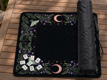 Black mahjong mat with luna moths, purple flowers, curling green vines, and a central play area with a purple border.