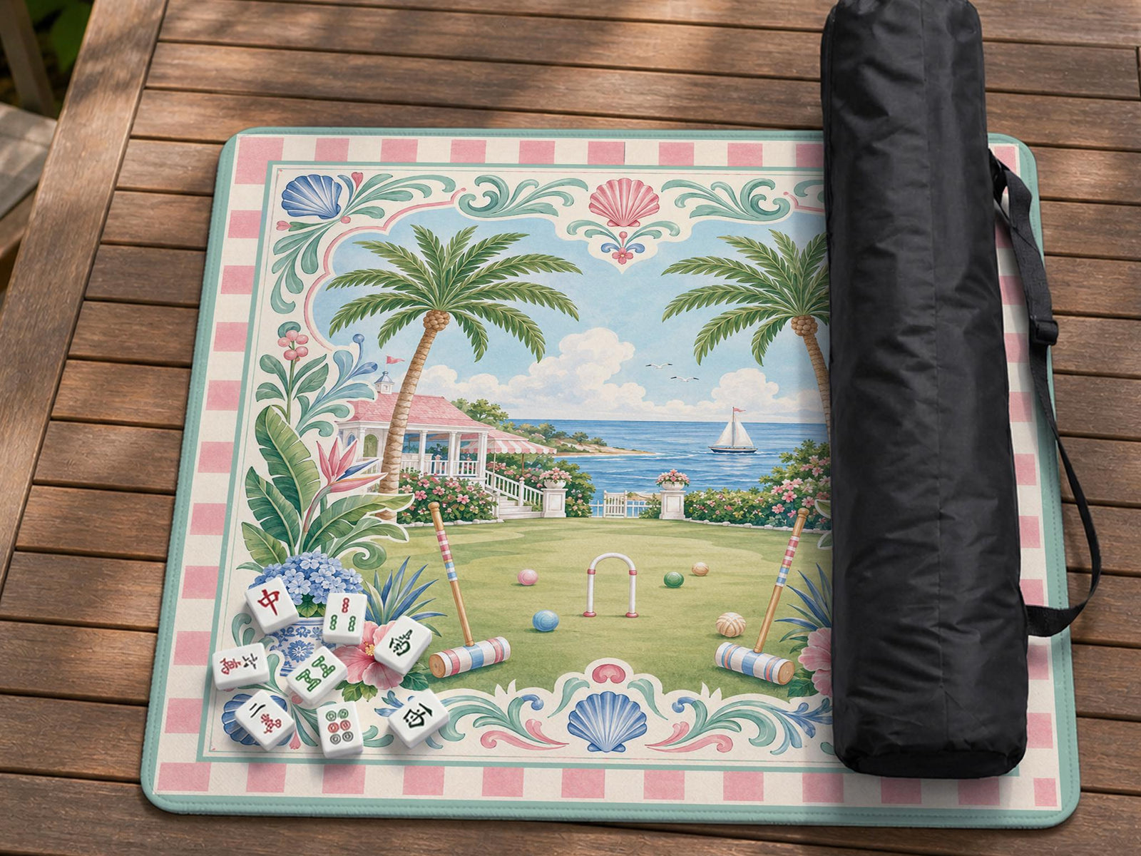 Pastel mahjong mat with a pink gingham border, seashells, hydrangea pots, palm trees, croquet details, and a coastal garden scene.