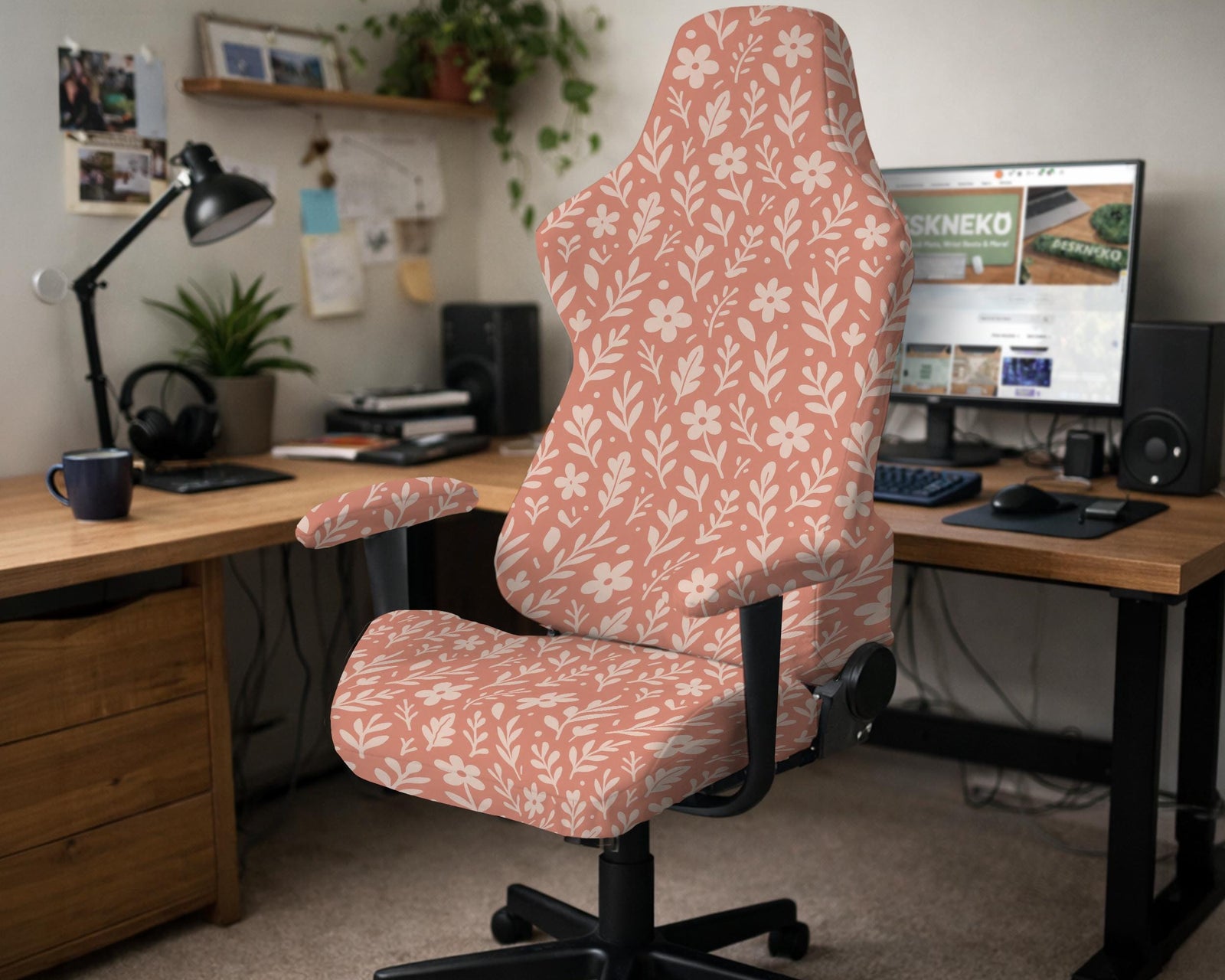 A peach chair cover with a white floral and botanical pattern shown on a computer chair.