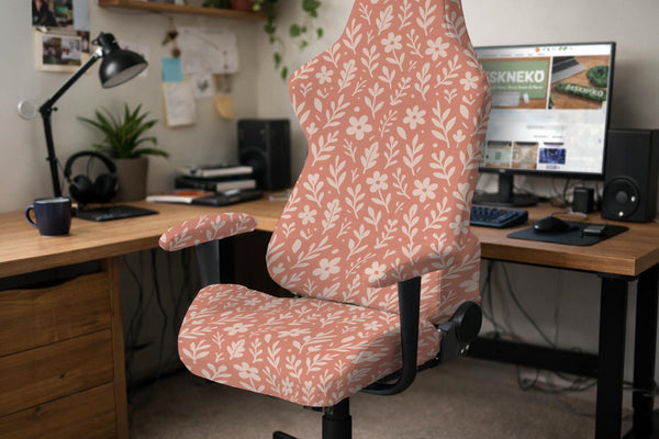A peach chair cover with a white floral and botanical pattern shown on a computer chair.