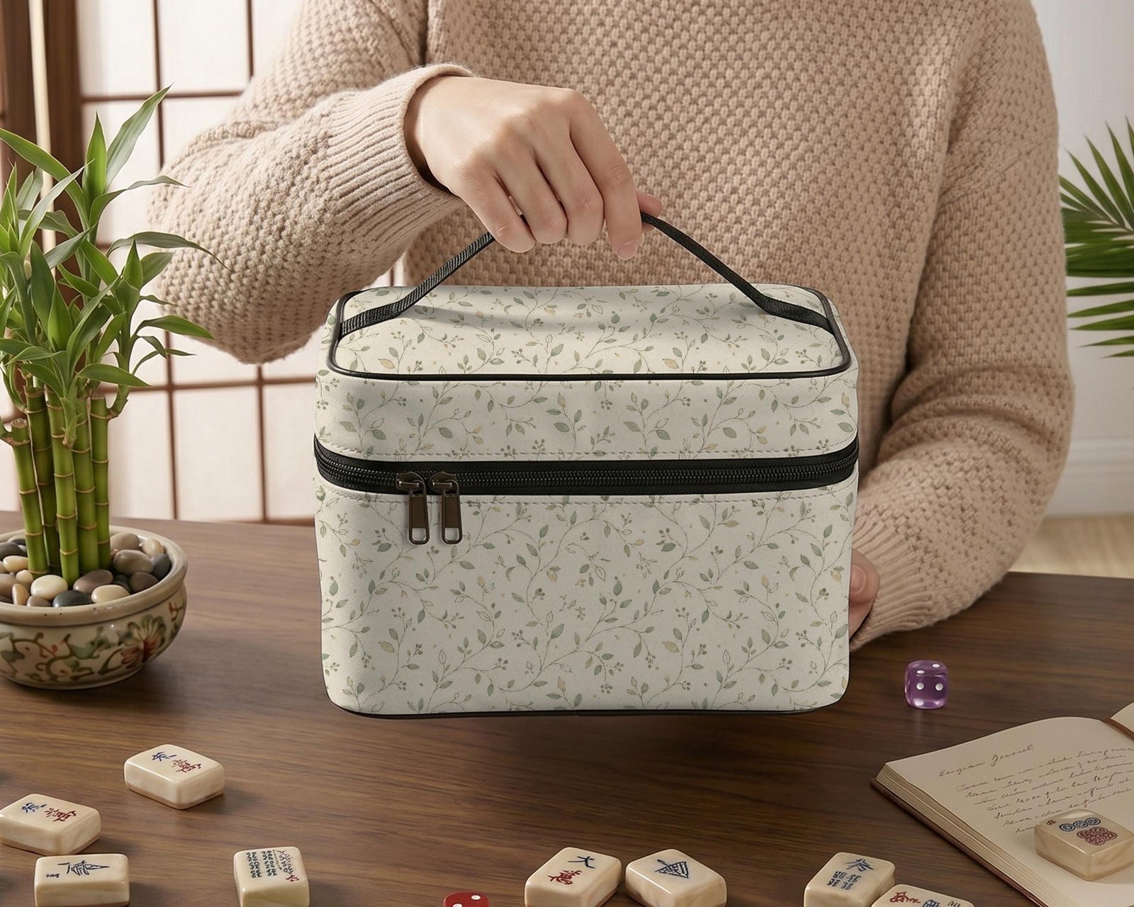 A beige Mahjong tile carrier bag with a sage green leaf pattern, zipper closure, and a top carry handle.