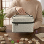 A beige Mahjong tile carrier bag with a sage green leaf pattern, zipper closure, and a top carry handle.