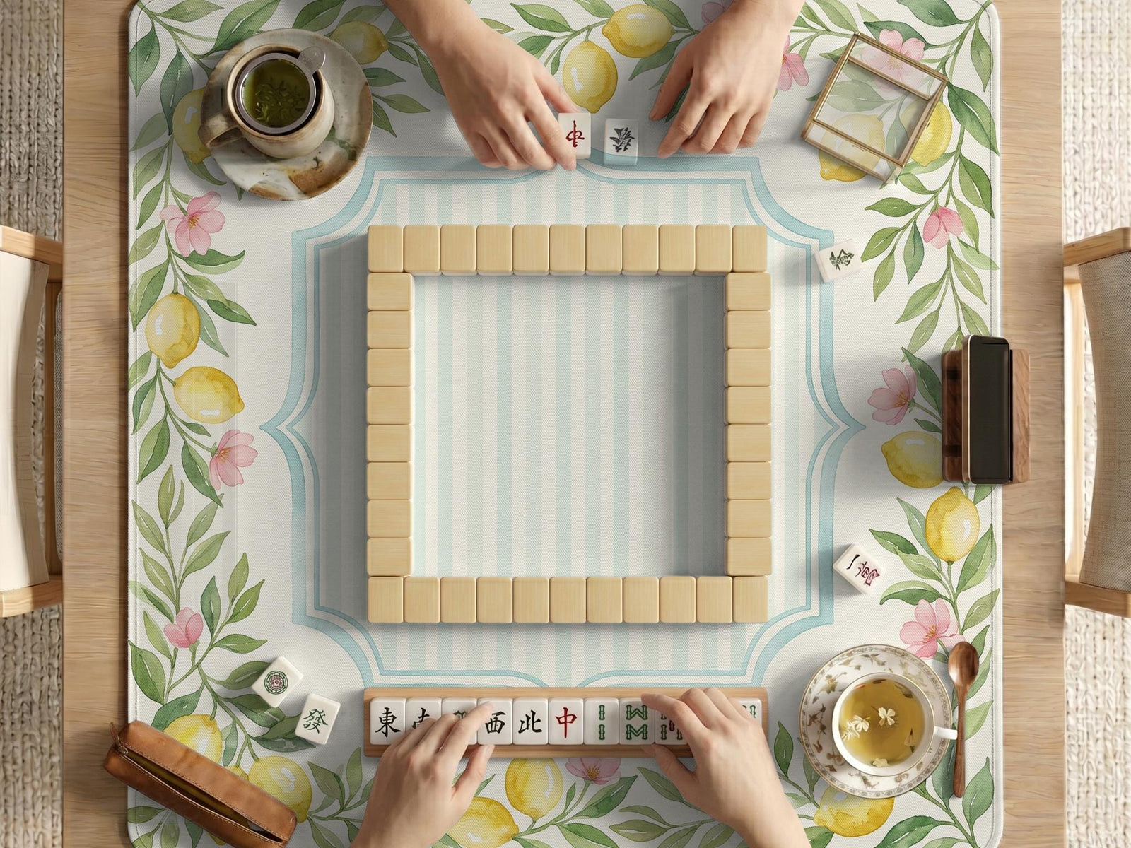 Square pastel yellow mahjong mat with lemon branches, small pink flowers, a striped center, and a light aqua border.