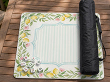 Square yellow mahjong mat with a citrus garden border, green vines, pink blossoms, aqua accents, and a plain center play area.