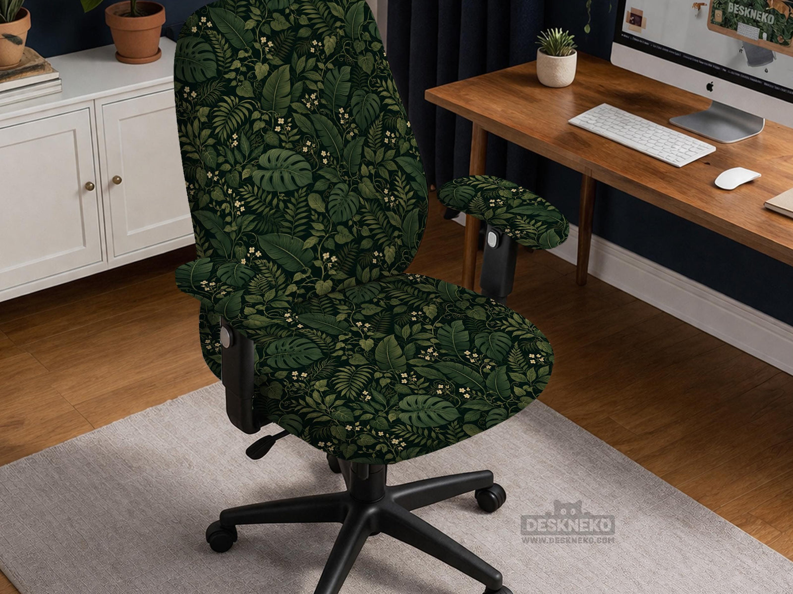 Forest green chair cover with a tropical leaf pattern featuring monstera leaves and small cream flowers.