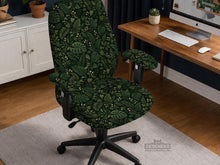 Forest green chair cover with a tropical leaf pattern featuring monstera leaves and small cream flowers.