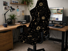 Black chair cover with a gold astrology print of moons, suns, stars, and symbols on a gaming chair.
