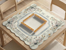 Beige square mahjong mat with a sage border, crane birds, bamboo, flowers, tile icons, and printed rules around a clean center play area.